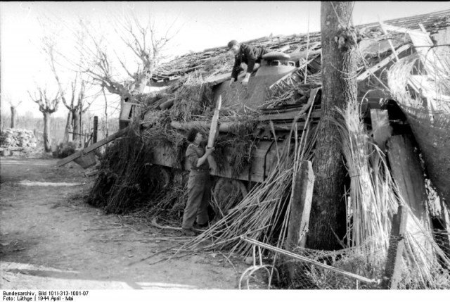 Near Cassino, a crew of a camouflaged Mark V "Panther" tank load ammunition.