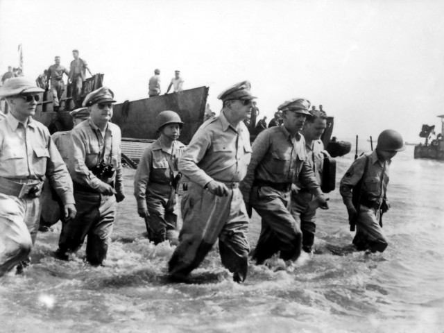 Gen. Douglas MacArthur wades ashore during initial landings at Leyte, Philippine Islands.