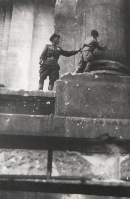 Volodya Tarnowski puts an autograph on a column of Reichstag, Berlin, 1945 (waralbum.ru)