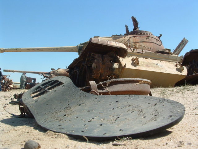 A shoe sole and rusting tanks lie along the Highway of Death in 2003. Photo Credit.