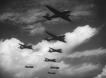 C-47 Skytrain transport aircraft in route to Normandy. After delivery of paratroopers, the planes returned to tow glider serials. The air eventually became congested with 2-way air traffic. Photo is a still frame from the movie Normandy: The Airborne Invasion of Fortress Europe, by the U.S. Army Air Forces (Image)