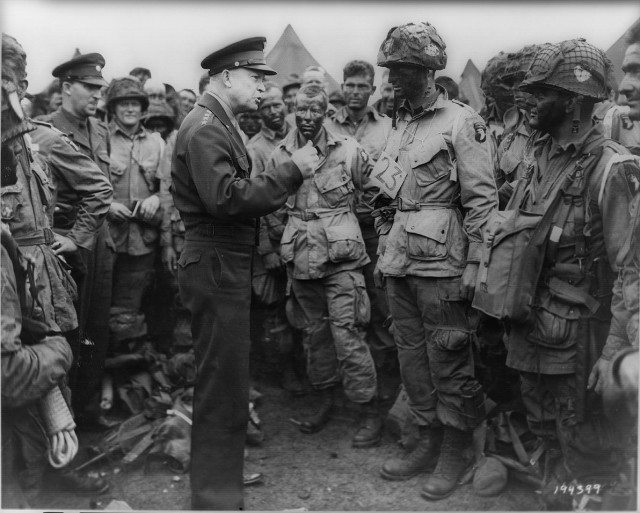 Dwight Eisenhower meets with 1st Lieutenant Wallace C. Strobel and men of Company E, 502nd Parachute Infantry Regiment prior to their night jump into Normandy (Image)