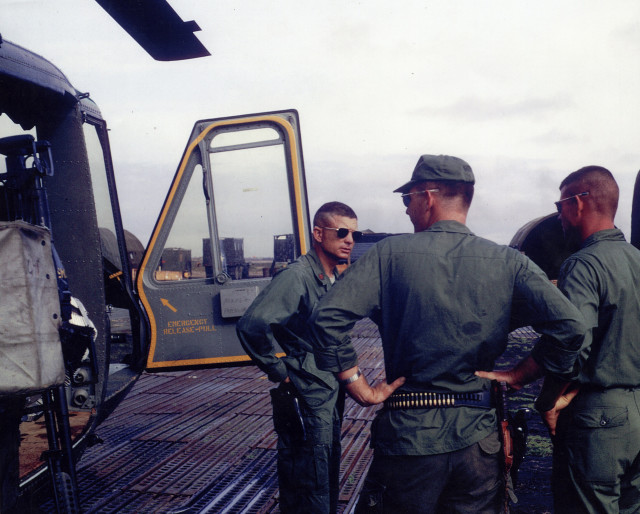U.S. Army Maj. Charles Kettles (left), standing beside his heavily damaged “Huey” helicopter on return from the May 15, 1967 emergency extraction rescue operation. (Photo courtesy of Retired U.S. Army Lt. Col. Charles Kettles)
