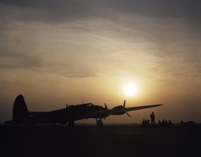 B-17 Flying Fortress bomber at rest, silhouetted by the setting sun, Langley Field, Virginia, United States, Jul 1942; note B-18 Bolo and two A-20 Havoc aircraft in background [Via].