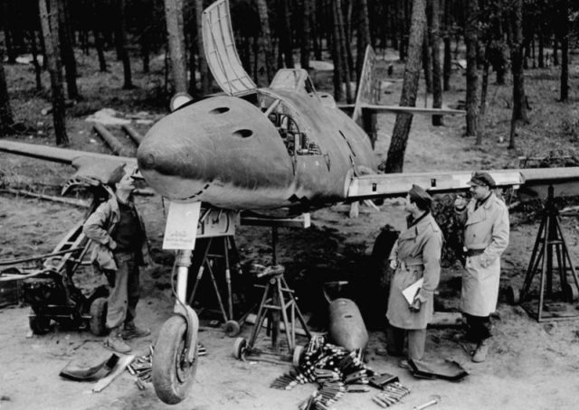 American officers and dismantled Messerschmitt Me.262 at the airport in the Frankfurt area on a plane no engines. shells visible to aerogun MK 108 next to the aircraft.