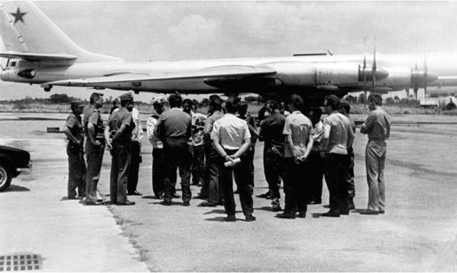 The Soviet crew explain details about their aircraft to their Cuban hosts. In the background, a TU-95 RTs