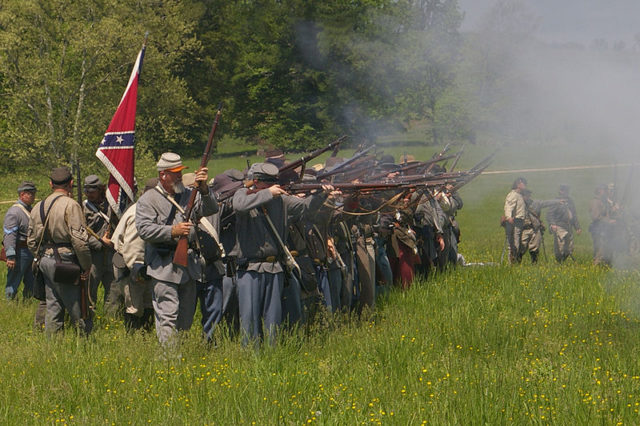 Confederate reenactors fire their rifles during a reenactment in 2008. Wikimedia Commons / MamaGeek / CC BY-SA 3.0 