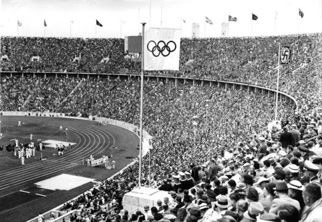 The Olympic flag and Nazi Flag seen flying side by side at the opening ceremony of the 1936 Olympic Games. 