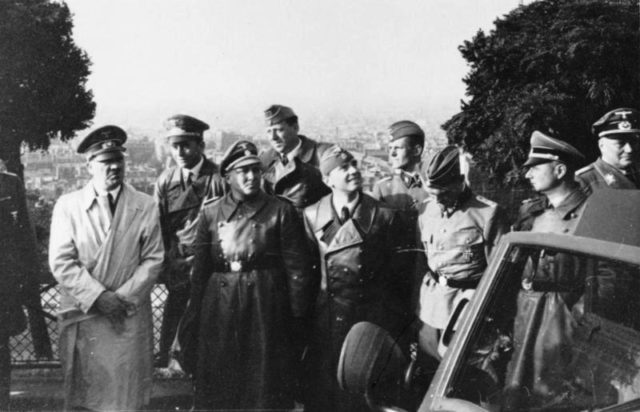 Bormann (on Hitler's left) in Paris, 1940. By Bundesarchiv, Bild 146-2004-0017 / Southard / CC-BY-SA 3.0, CC BY-SA 3.0 de, https://commons.wikimedia.org/w/index.php?curid=5483770