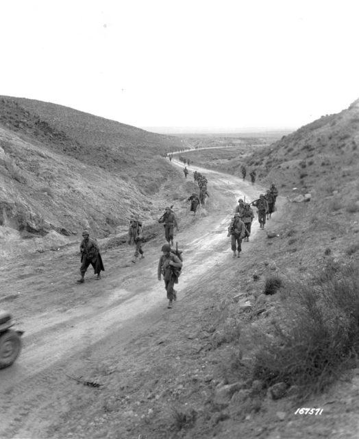 Men of the 2nd Battalion, 16th Infantry Regiment of the U.S. 1st Infantry Division march through the Kasserine Pass and on to Kasserine and Farriana, Tunisia February 26, 1943. Wikimedia Commons / Public Domain