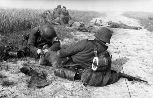 A German Military Medic providing first aid to a wounded soldier. Photo Credit.