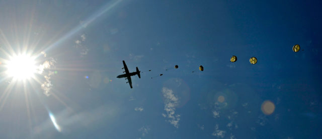 A U.S. Air Force C-130J Super Hercules flies over Iron Mike memorial dropping paratroopers here, June 8, 2014. More than 600 U.S., German, Dutch and French service members jumped to honor the paratroopers that jumped into Normandy on D-Day. (U.S. Air Force photo/Staff Sgt. Sara Keller)