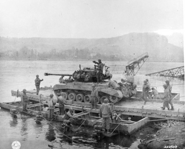 A Pershing T26E3 of A Company, 14th Tank Battalion, is transported aboard a pontoon ferry across the Rhine on 12 March 1945 (Wikipedia / Public Domain)