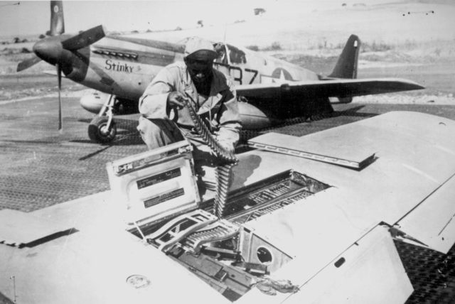 A USAAF armourer of the 100th Fighter Squadron, 332nd Fighter Group, 15th U.S. Air Force checks ammunition belts of the .50 caliber (12.7 mm) machine guns in the wings of a North American P-51B Mustang in Italy, ca. September 1944. 