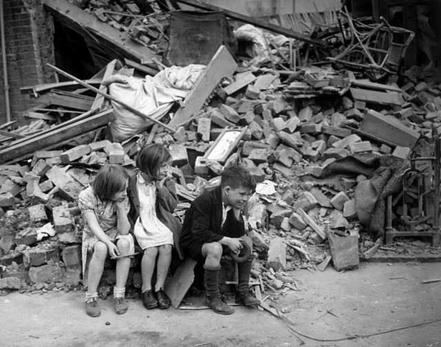 Children sit among the rubble in East London. 