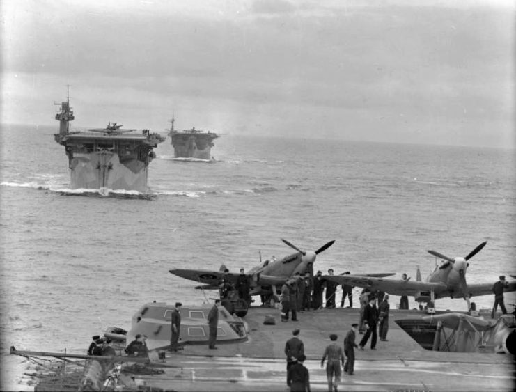 The Royal Navy escort carriers HMS Biter (D97) and HMS Avenger (D14) underway in line astern from the aircraft carrier HMS Victorious (R38). Two Supermarine Seafires of 884 Naval Air Squadron, Fleet Air Arm, can be seen at the far end of the flight deck of HMS Victorious.