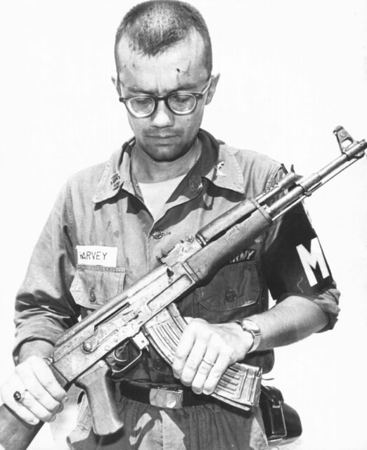 A U.S. Army M.P inspects a Chinese AK-47 recovered in Vietnam, 1968.