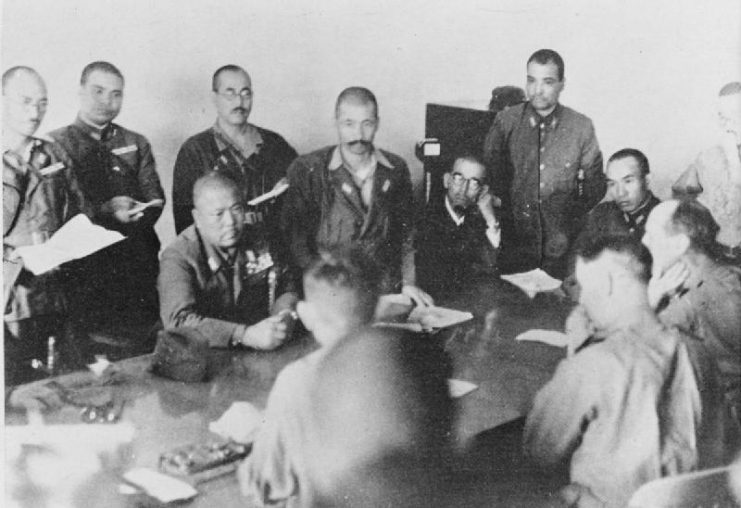 Lt. Gen. Yamashita Tomoyuki (seated, center) insists upon the unconditional surrender of Singapore as Lt. Gen. Percival, seated between his officers, demurs (photo from Imperial War Museum)