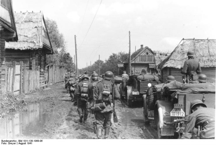 German troops advances through a village near Minsk, August 1941. By Bundesarchiv – CC BY-SA 3.0 de