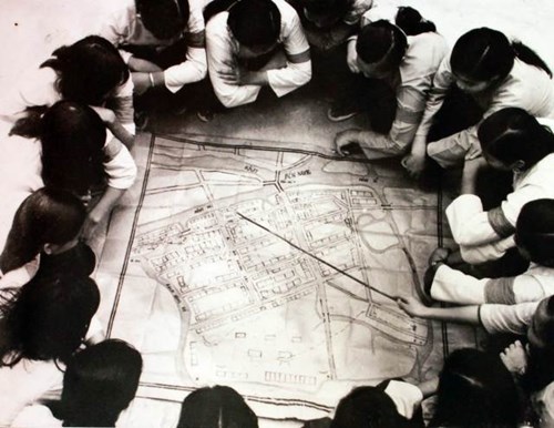 Female special forces of the People’s Liberation Armed Forces of South Vietnam studies maps of District 7, Saigon, prior to the Tet Offensive.