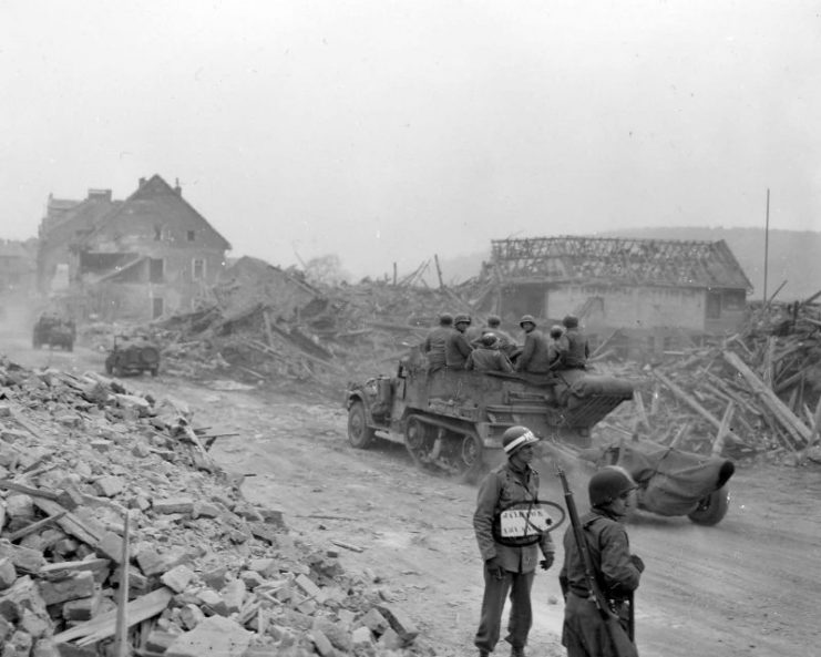 1st Army MP and M3 Halftracks with trailers in Ruins of Alterkirchen Germany 1945