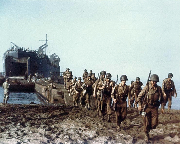 A U.S. Navy Landing Ship-Tank (LST-1) landing American Army troops—possibly from the 36th Division—on an Italian beach, via a causeway.