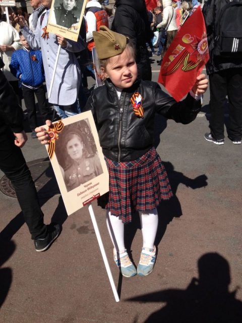 Young Russian Girl Dressed for Victory Day with a Photo of her Great Grandmother who Fought in the Great Patriotic War.