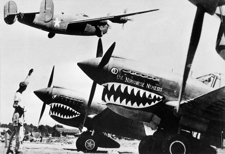 A B-24 flies over two P-40 Warhawks
