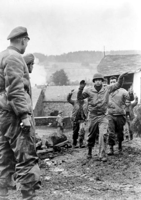American soldiers of the 3rd Battalion 119th Infantry Regiment are taken prisoner by members of Kampfgruppe Peiper in Stoumont, Belgium on 19 December 1944.Photo: Bundesarchiv, Bild 183-J28619 Büschel CC-BY-SA 3.0
