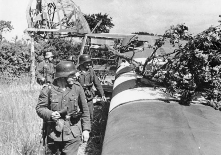 An abandoned Waco CG-4 glider is examined by German troops. Photo: Bundesarchiv, Bild 146-2004-0176 / CC-BY-SA 3.0