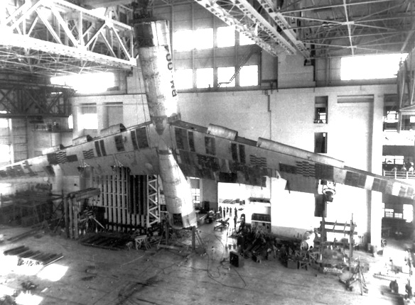 A B-36 airframe undergoing structural stability tests. Note for scale the three men in the balcony at the extreme right of the photograph.