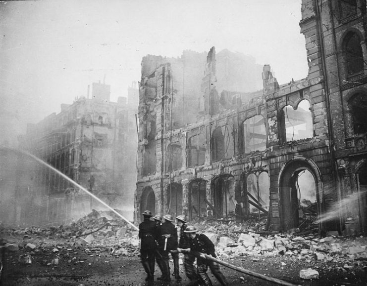 Firefighters tackling a blaze amongst ruined buildings after an air raid on London