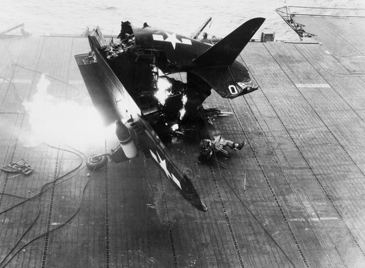 A U.S. Navy Curtiss SB2C-4E Helldiver crumples in flames during a horrific crash landing aboard the aircraft carrier USS Shangri-La (CV-38)