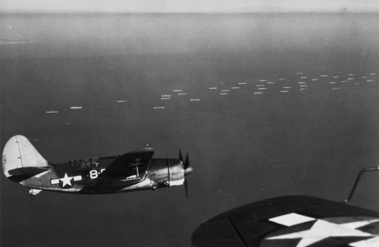 U.S. Navy Curtiss SB2C-1 Helldiver scout-bombers from Bombing Squadron 8 (VB-8) fly near a convoy, in the Hampton Roads-Chesapeake Bay area, December 1943.