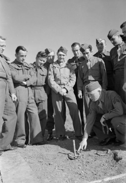 American camp in Dorset, UK: US sergeant explains how to play the game of “horseshoes” to soldiers of a British searchlight unit billeted nearby.