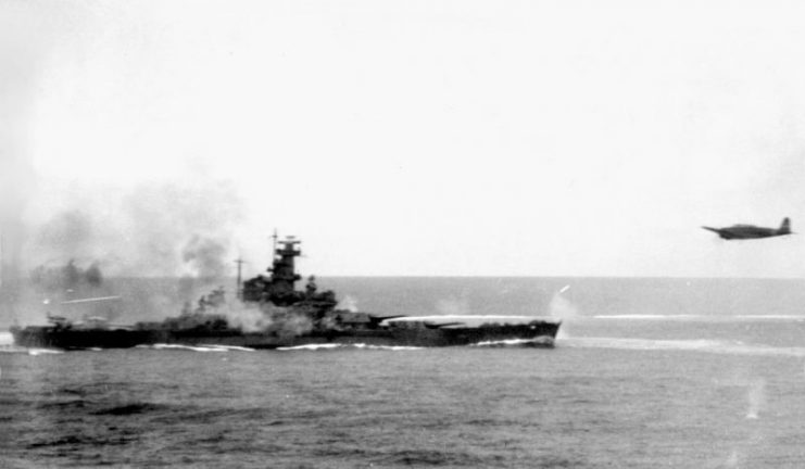 South Dakota fires at a Japanese torpedo bomber (right) during a battle. The smoke around the battleship is from the ship’s anti-aircraft guns.
