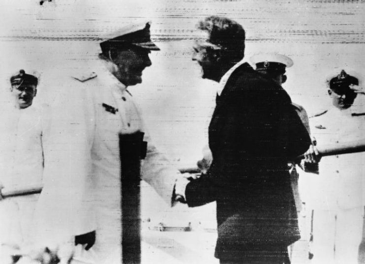 Harwood is greeted by the British Minister to Uruguay, Mr E Millington-Drake after his arrival at Montevideo after the Battle of the River Plate