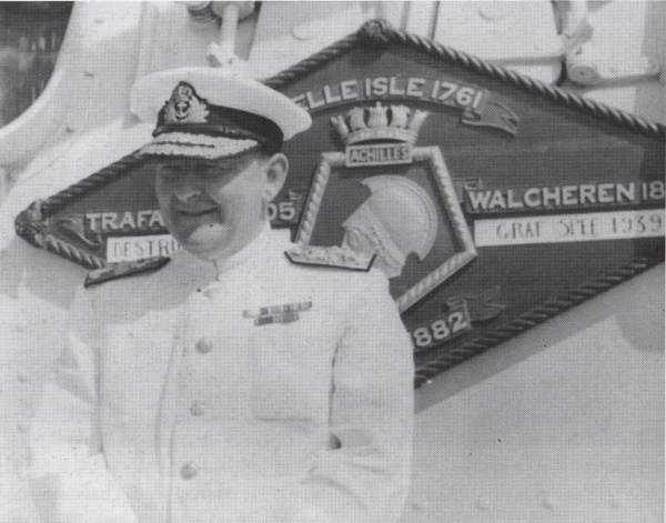 Photograph of Rear-Admiral Sir Henry Harwood, soon after being promoted to Rear-Admiral, in front of the battle honour board of HMNZS Achilles.