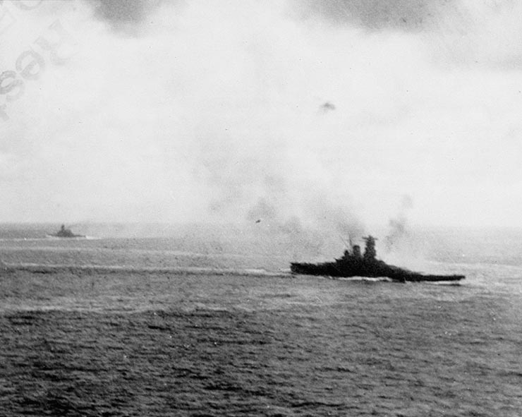 The Japanese battleship Yamato (right) in action with U.S. carrier planes off during the Battle off Samar, 25 October 1944. Another battleship is in the left distance, steaming in the opposite direction.