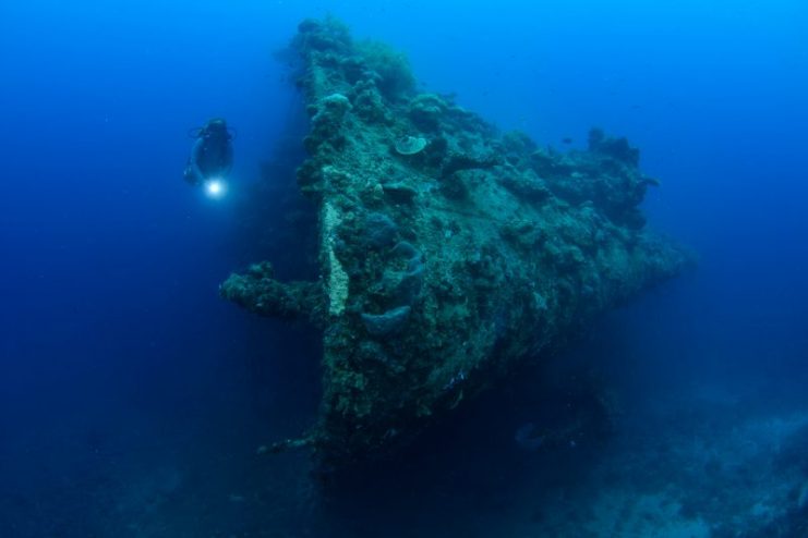 Diver exploring the bow of a Shipwreck; a ship sunk by American dive bombers in WW2
