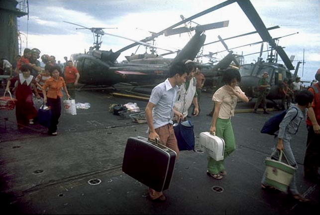 South Vietnamese refugees walk across a U.S. Navy vessel (probably USS Hancock (CVA-19)) during Operation Frequent Wind.