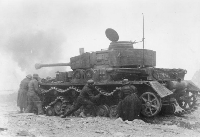 A German tank recovery crew tries to get a disabled tank moving again.