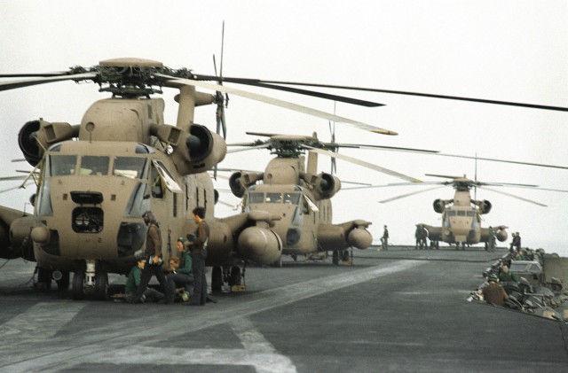 Three RH-53 Sea Stallion helicopters are lined up on the flight deck of the nuclear-powered aircraft carrier USS NIMITZ (CVN-68) in preparation for Operation Evening Light, a rescue mission to Iran.