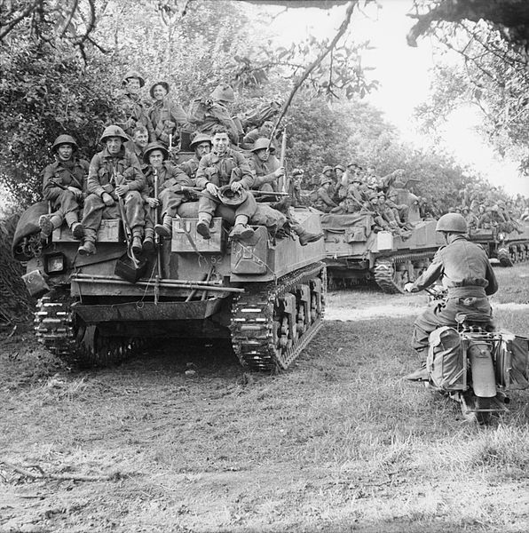 Sherman tanks of the Staffordshire Yeomanry, 27th Armored Brigade, carrying infantry from 3rd Division, move up at the start of Operation ‘Goodwood’, Normandy, 18 July 1944.