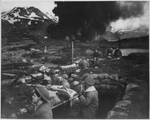 lossy-page1-1280px-Japanese_attack_on_Dutch_Harbor,_June_3,_1942._Group_of_Marines_on_the_-alert-_between_attacks._Smoke_from_burning..._-_NARA_-_520589.tif