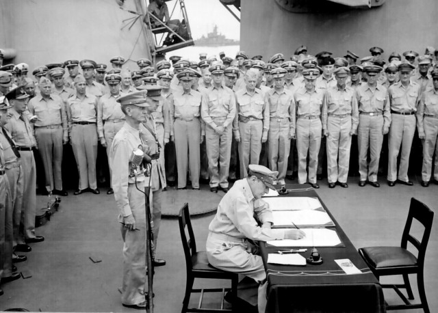 General of the Army Douglas MacArthur signing the Instrument of Surrender on behalf of the Allied Powers.