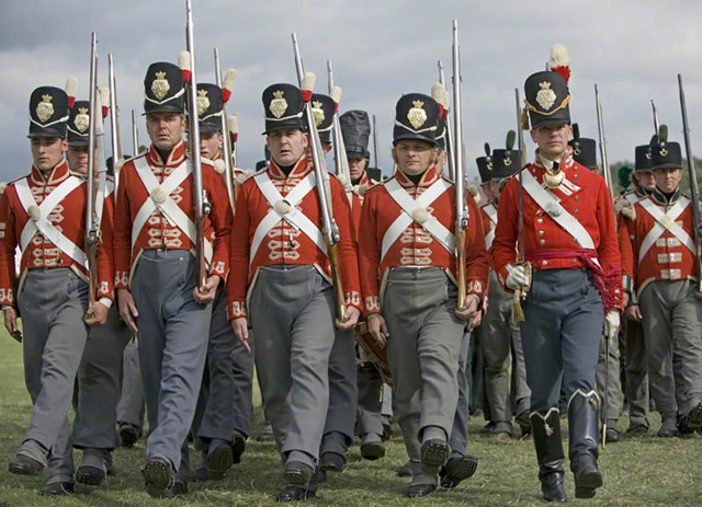 Reenactors in the red-coated uniform of the 33rd Regiment of Foot as worn during the Napoleonic Wars between 1812 and 1816. Note the brighter scarlet of the officer on the right. - By WyrdLight.com, CC BY-SA 3.0