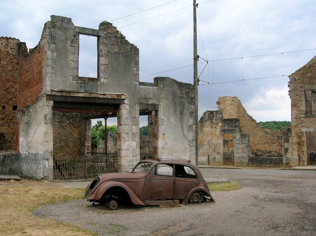 Destroyed Peugeot 202 and some buildings in Oradour-sur-Glane. Photo: TwoWings / CC BY-SA 3.0