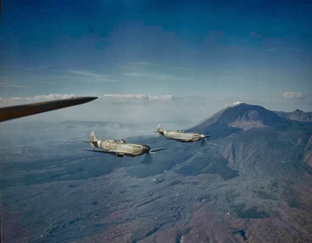 RAF Spitfires flying past Mount Vesuvius, Italy, 1944. © IWM (TR 1536)