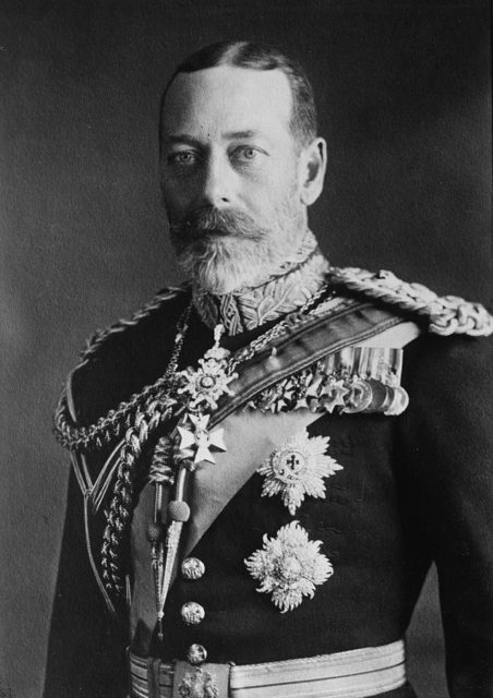 Pale-eyed grey-bearded man of slim build wearing a dress uniform and medals More details King George V in 1923.